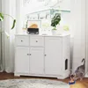 A white cabinet for a cat litter box is shown in a room with a window and curtains. A cat is eating from a bowl in front of the cabinet. Produktbild-Vorschau