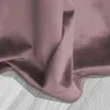 A close-up view of a pink velvet curtain draped over a wooden surface. Podgląd zdjęcia produktu
