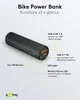A black cylindrical bike power bank is shown with labels pointing to its various features and ports. Produktbild-Vorschau