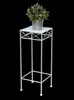 A white metal plant stand with a potted green plant on top, set against a black background. Anteprima dell’immagine prodotto
