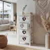 A chest of drawers with heart cutouts in a living room setting. Anteprima dell’immagine prodotto