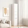 A tall white cabinet with three doors stands in a room with a sofa and a painting on the wall. Podgląd zdjęcia produktu