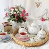 A tea set with flowers and a decorative shoe. Produktbild-Vorschau
