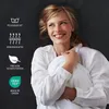 A woman is lying in bed, holding a pillow and smiling. There are icons and text on the left side of the image highlighting product features. Produktbild-Vorschau