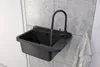 A black sink with a faucet running water, mounted on a tiled wall. Anteprima dell’immagine prodotto
