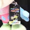 A close-up of a Disney Tie Dye Mickey Mouse plush toy with its tag. Voir les images du produit