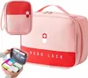 A product shot of a pink and red first aid kit with a smaller, open version of the kit showing its contents. Náhľad obrázku produktu
