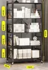 A black metal folding shelf unit filled with books and decorative items, with measurement indicators on the side. Produktbild-Vorschau