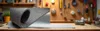 A roll of thick gray felt fabric is partially unrolled on a wooden workbench, with tools visible in the background. Náhled obrázku produktu