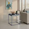 A modern living room scene with a side table, sofa, and abstract art. Voir les images du produit