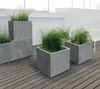 Modern outdoor patio with grey planters and green grass. Náhled obrázku produktu