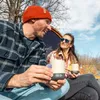 Zwei Personen sitzen im Freien und halten die Climbing Mug Evo Keramiktasse mit Klettergriff von YY Vertical. Eine Person trägt eine rote Mütze; die andere eine Sonnenbrille. Podgląd zdjęcia produktu