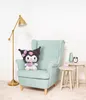 A plush toy is sitting on a chair in a room with a lamp and side tables. Voir les images du produit