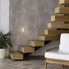 A modern interior with a floating wooden staircase and a wall-mounted light. Anteprima dell’immagine prodotto