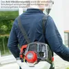 A person wearing a blue shirt and a backpack with a red and black engine. The person is outdoors, possibly in a garden or yard. Produktbild-Vorschau
