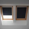 Two dark blue blackout blinds installed in wooden framed skylights. Produktbild-Vorschau