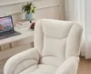 A close-up view of a fluffy cream-colored office chair, with a desk and laptop visible in the background. Produktbild-Vorschau
