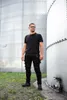 A man stands between two large industrial silos. Anteprima dell’immagine prodotto
