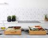 Two Princess Chef-Tischgrill Dinner4All Pure 840 W grills are set up on a kitchen counter, each with food being cooked on them. The background features a modern tiled backsplash and a stovetop. Produktbild-Vorschau