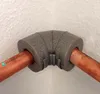A close-up shot of a 90-degree pipe elbow insulation with copper pipes inserted. Produktbild-Vorschau
