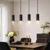 A dining table set with candles and a floral arrangement, illuminated by pendant lights. Podgląd zdjęcia produktu