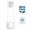 A clear glass water carafe with a white lid, filled with water and showing small water droplets on the outside. It is placed on a white background with marketing text and logos. Produktbild-Vorschau
