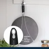 A splatter screen for a pan is hanging on a hook against a light-colored wall. A close-up inset shows the handle with a hanging hook. Text highlights the hanging hook feature. Produktbild-Vorschau