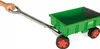 A hand holding the handle of a green wagon with silver metal parts and red-rimmed wheels. Voir les images du produit
