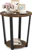 A round, two-tiered side table with a rustic brown wood finish and black metal legs, decorated with a vase of flowers, picture frames, and a cup of coffee. Náhled obrázku produktu