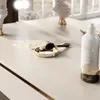 A close-up view of a vanity table with makeup brushes, a cream jar, and a lotion bottle. Produktbild-Vorschau