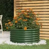 A green metal planter filled with orange flowers, placed on grass and white pebbles, with a wooden fence in the background. Anteprima dell’immagine prodotto