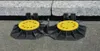 Two adjustable pedestals for a raised floor system are shown on a paved surface, with large stone slabs resting on top. Anteprima dell’immagine prodotto