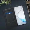 A smartphone with a flip case and a credit card inside, placed on a dark surface next to a laptop keyboard. Produktbild-Vorschau