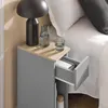 A close-up view of a narrow bedside table next to a bed. Produktbild-Vorschau