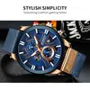 A close-up shot of a men's wristwatch with a blue dial and gold accents, placed on a dark, textured surface. Text overlays provide marketing information. Produktbild-Vorschau