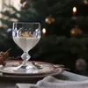 A dessert in a glass is placed on a plate, with a Christmas tree in the background. Voir les images du produit
