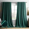 A room with dark green velvet curtains hanging over a window, with a chair and a small table visible.