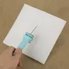 A hand holding a foam cutter to cut a piece of white foam. Produktbild-Vorschau