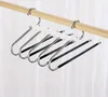 A multi-bar hanger for trousers hangs on a wooden rod. Anteprima dell’immagine prodotto