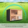 A rabbit hutch with a cover, set in a grassy field with mosquitoes depicted in the air. Produktbild-Vorschau