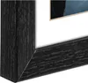A close-up view of a black picture frame with a tan mat and a portion of a picture visible. Anteprima dell’immagine prodotto