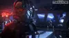 A character in a helmet with red glowing eyes, wearing armor, stands in a dimly lit interior with blue lighting in the background. Produktbild-Vorschau