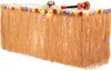 A table decorated with a grass skirt and leis, with a toy ukulele on top. Podgląd zdjęcia produktu