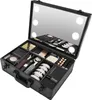 An open black makeup case filled with various makeup products, with a mirrored lid featuring LED lights. Produktbild-Vorschau