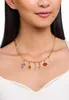A woman wearing a gold charm necklace. Anteprima dell’immagine prodotto