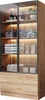 A tall, narrow cabinet with glass doors and LED lighting, displaying towels, bottles, and boxes on shelves, and two drawers at the bottom. Voir les images du produit