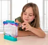 A young girl is looking at a small aquarium with tiny creatures inside, holding a magnifying glass. Voir les images du produit