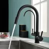 A black kitchen faucet with water running into a sink, with a bowl of cherries and storage containers in the background. Produktbild-Vorschau