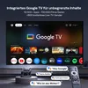 A smart projector displaying the Google TV interface on a large screen, with a remote control and voice assistant prompts visible. Produktbild-Vorschau