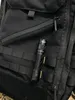 A black flashlight is attached to a black tactical backpack. Produktbild-Vorschau